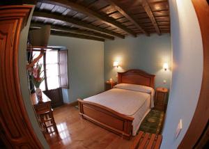 Puentenansa波萨达菲德尔旅馆的一间卧室设有一张大床和一个窗户。