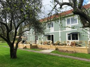 SunnemoThe Green House Guesthouse的绿色的房子,设有木甲板和一棵树