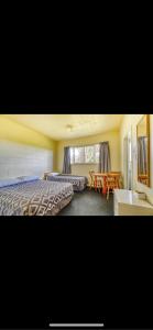 Te KaoTekao Lodge的酒店客房设有两张床和一张桌子。