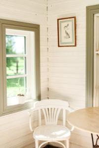 IgakülaMatsi cottage的窗户客房内的一张桌子和两把白色椅子