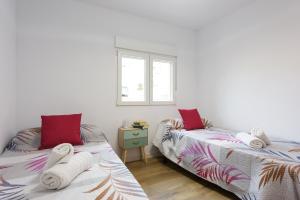 格拉纳达Apartamento Lagloria的一间卧室配有两张带毛巾的床