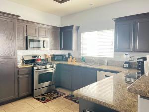 拉斯维加斯Oasis pool house, optional pool heater的厨房配有蓝色橱柜和炉灶烤箱。