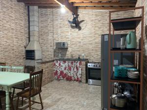 洛韦拉Casa 1km Anhanguera e Churrasqueira Wi-Fi的厨房配有桌子和炉灶。 顶部烤箱