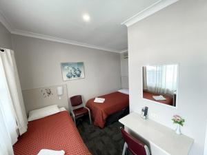 古尔本Hillview Motel的小房间设有两张床和镜子