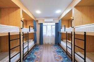 比什凯克Kaganat Hostel的客房设有四张双层床和窗户。