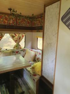 KoppányszántóKoppány Pines Rewild Escapes - Vintage Caravan的一间配有沙发的房间和一张火车桌