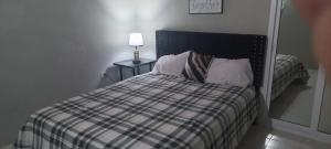 蒙特哥贝Oak Villa Montego Bay 2的一间卧室配有一张床和一张桌子上的台灯