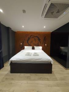 曼谷諾姆酒店的一间卧室配有一张大床和木制床头板
