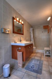 韦尔纳亚Rêves Gourmands, Hôtellerie & Gastronomie的浴室配有盥洗盆、镜子和浴缸