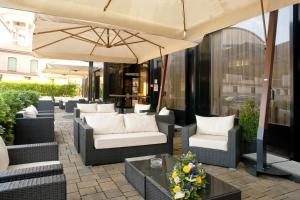 维罗纳圣皮耶特罗酒店的庭院配有椅子、遮阳伞和桌子。