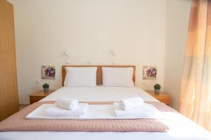 阿吉奥斯普罗科皮奥斯Naxian Place的一间卧室配有一张大床和两条毛巾