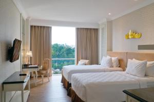 班达楠榜兰蓬瑞士贝尔酒店的酒店客房设有两张床和窗户。