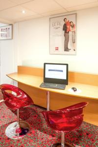 梅斯梅斯中心大教堂宜必思酒店的一张带笔记本电脑和红色椅子的桌子
