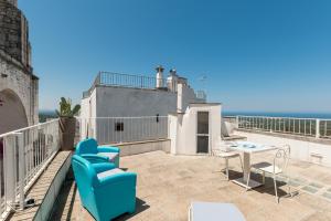 奥斯图尼Dimore del TEMPO PERS0 Prima Luce的阳台设有带蓝色椅子和桌子的庭院。