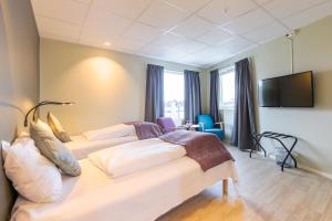 布伦讷于松Corner Hotell的酒店客房设有两张床和一台平面电视。