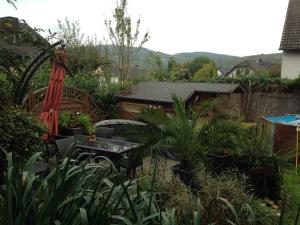 Riol特雷恩雷蒙娜度假屋的花园配有桌椅和遮阳伞。