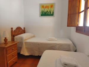 克莉丝蒂娜岛Sol y Mar的一间卧室设有两张床、一个梳妆台和窗户。