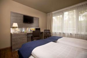 乌尔姆奥特姆贝斯特韦斯特酒店的一间卧室配有一张床、一张书桌和一台电视