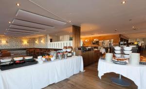 纳沙泰尔贝拉克财富品位酒店的餐厅设有白色桌子,提供食物