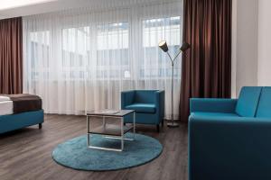 多特蒙德多特蒙德机场贝斯特韦斯特酒店的酒店客房带两把蓝色椅子和一张床