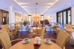 吕讷堡贝斯特韦斯特高级卡斯坦萨度假酒店酒店的餐厅设有木桌、椅子和窗户。