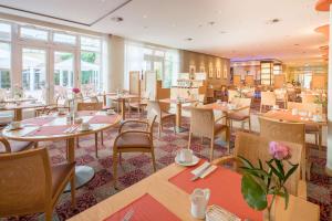 吕讷堡贝斯特韦斯特高级卡斯坦萨度假酒店酒店的餐厅设有桌椅和窗户。