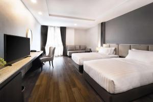 曼谷SureStay Plus by Best Western Sukhumvit 2的酒店客房设有两张床和一台平面电视。