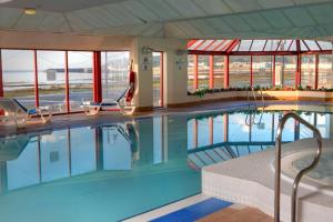 道格拉斯贝斯特韦斯特宫殿酒店&赌场的一个带两把椅子和窗户的大型游泳池