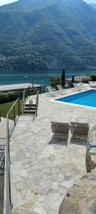 拉利奥Villa Ortensia的一个带椅子的庭院和一个毗邻水面的游泳池
