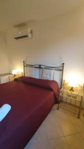 诺托玛丽娜""" Holiday Properties Sicilian Breeze """的一间卧室配有一张带红色毯子的床和两把椅子