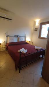 诺托玛丽娜""" Holiday Properties Sicilian Breeze """的一间卧室配有一张带红色床单的床和一扇窗户。