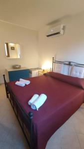 诺托玛丽娜""" Holiday Properties Sicilian Breeze """的一间卧室配有红色大床和毛巾