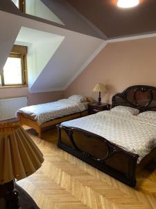 诺维萨德Relax and pool apartments Novi Sad的一间设有两张床的卧室,位于带屋顶的房间