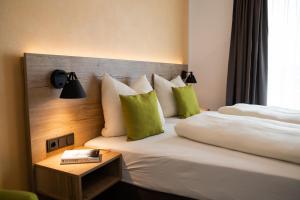 StubersheimAlbhotel Bahnhöfle的酒店的客房 - 带两张带绿色枕头的床