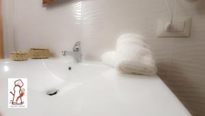 那不勒斯Terramia Holiday House的白色的浴室设有水槽和毛巾