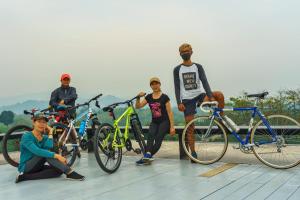 清莱SukSanti CoLiving and Vacation的一群人站在自行车旁边