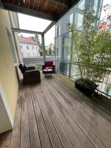 格拉茨Zentrum & Schöne Terasse的阳台的甲板上配有沙发和椅子