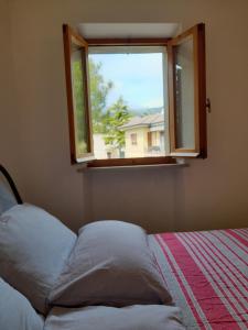 锡罗洛Appartamento a Sirolo centro的一间卧室设有一张床和一个窗口