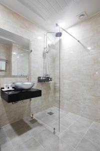 平昌玛茹酒店的一间带水槽和玻璃淋浴的浴室