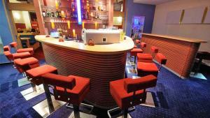 耶塞尼克Hotel Slovan的餐厅的酒吧,有红色凳子