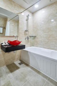平昌玛茹酒店的带浴缸和红色盥洗盆的浴室