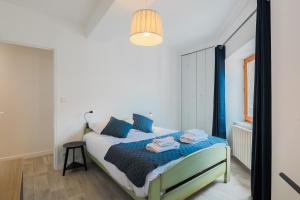 克莱蒙费朗La Halte de Saint-Pierre的一间卧室配有一张带蓝色枕头的床