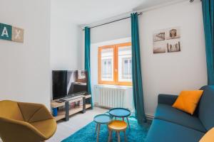 克莱蒙费朗La Halte de Saint-Pierre的客厅配有蓝色的沙发和电视