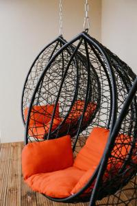 派尔努维斯鲁斯公寓的摆在房间里的带橙色枕头的秋千椅