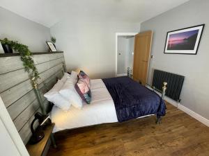 马伯斯Stunning 1 bedroom Flat in The Mumbles的一间卧室配有带白色床单和枕头的床。