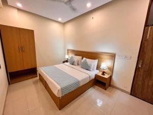 诺伊达Hotel Mithila Residency Noida - Couple Friendly Local IDs Accepted的一间卧室配有一张床和两张台灯。