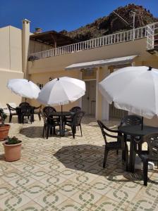 圣地亚哥海滩马特尔公寓的庭院里摆放着桌椅和遮阳伞