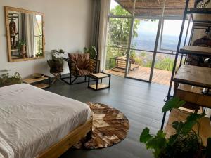 基加利Eagle View Lodge - Kigali的一间卧室设有一张床,享有阳台的景色
