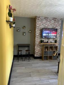 泰恩河畔纽卡斯尔Nuns Moor fully equipped kitchen free parking Netflix的一间带电视和砖墙的客厅