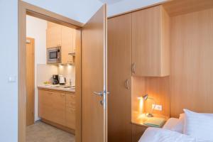 魏森湖Draxl-Hof Ferienwohnungen的一间卧室配有一张床和一个小厨房